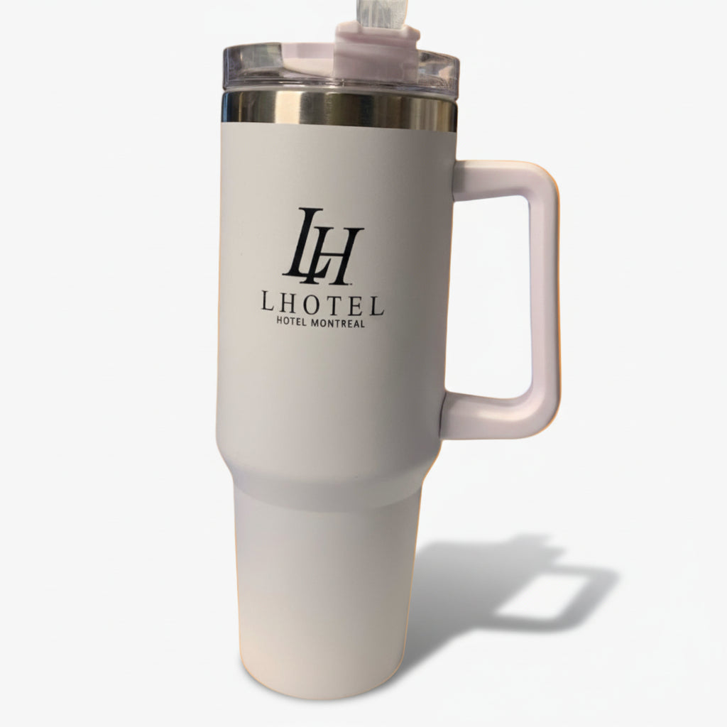 A white plastic water quencher with a pink handle and the LHotel Montreal logo, equipped with a straw.