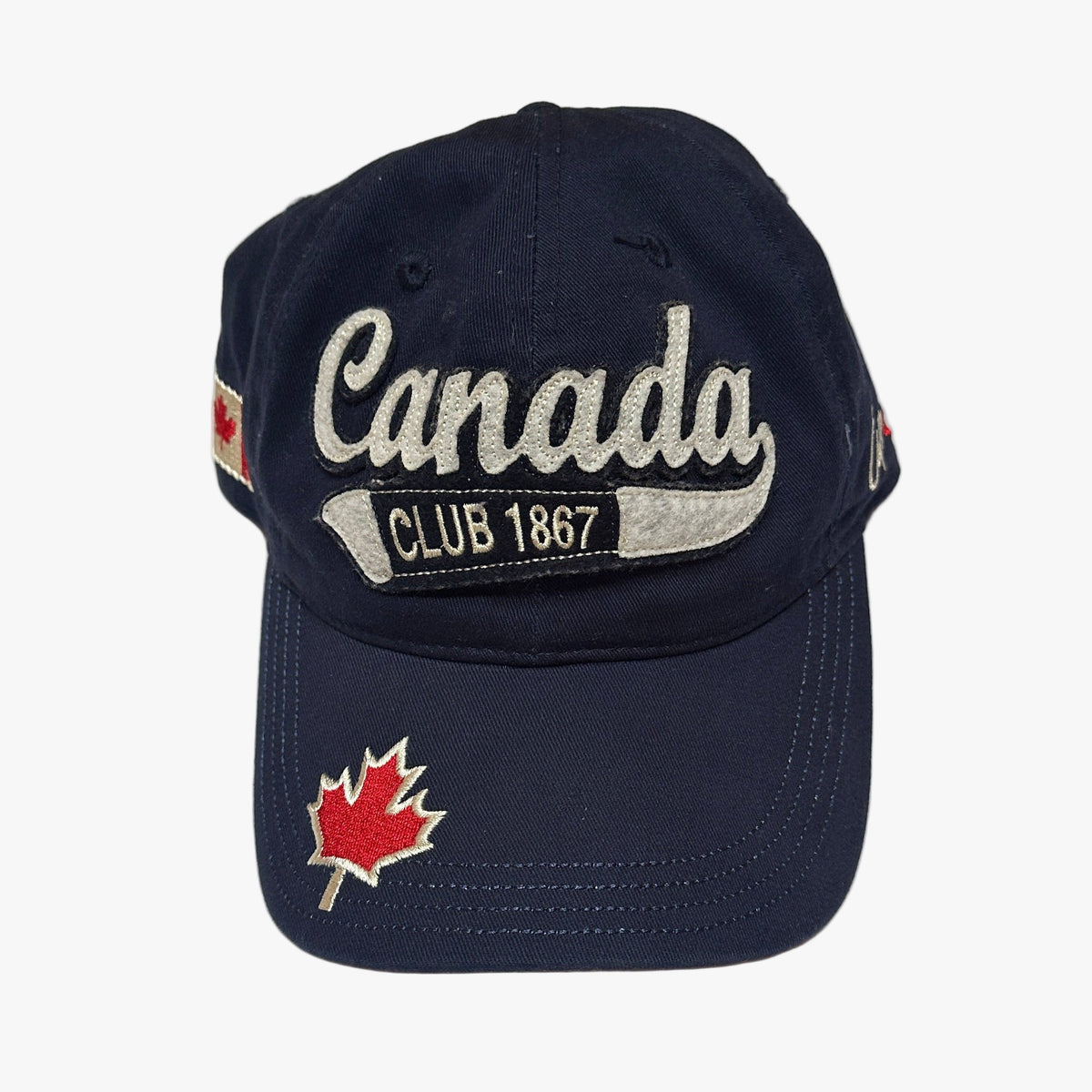 Navy blue cap with 'Canada Club 1867' text and maple leaf design on a white background